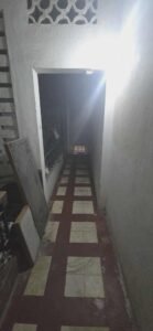 Narrow hallway inside an older Phnom Penh apartment building with tiled floor and natural light from above