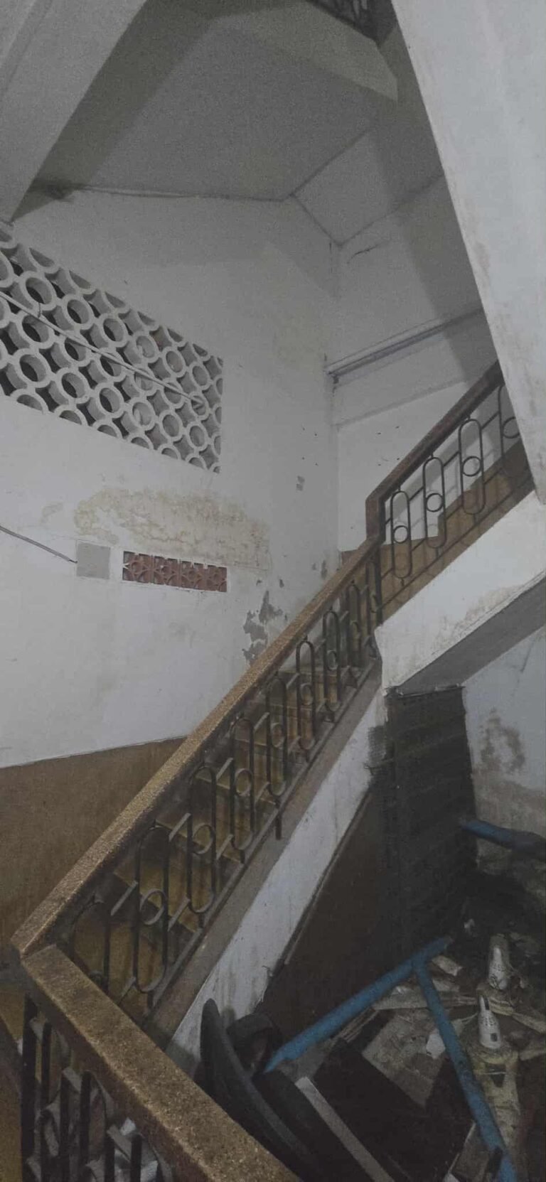 Interior staircase inside an older Phnom Penh building leading up to the apartment floors